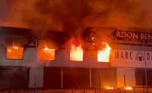 Huge fire rips through building and busy roads close down during rush hour as emergency services rush to deal with raging inferno